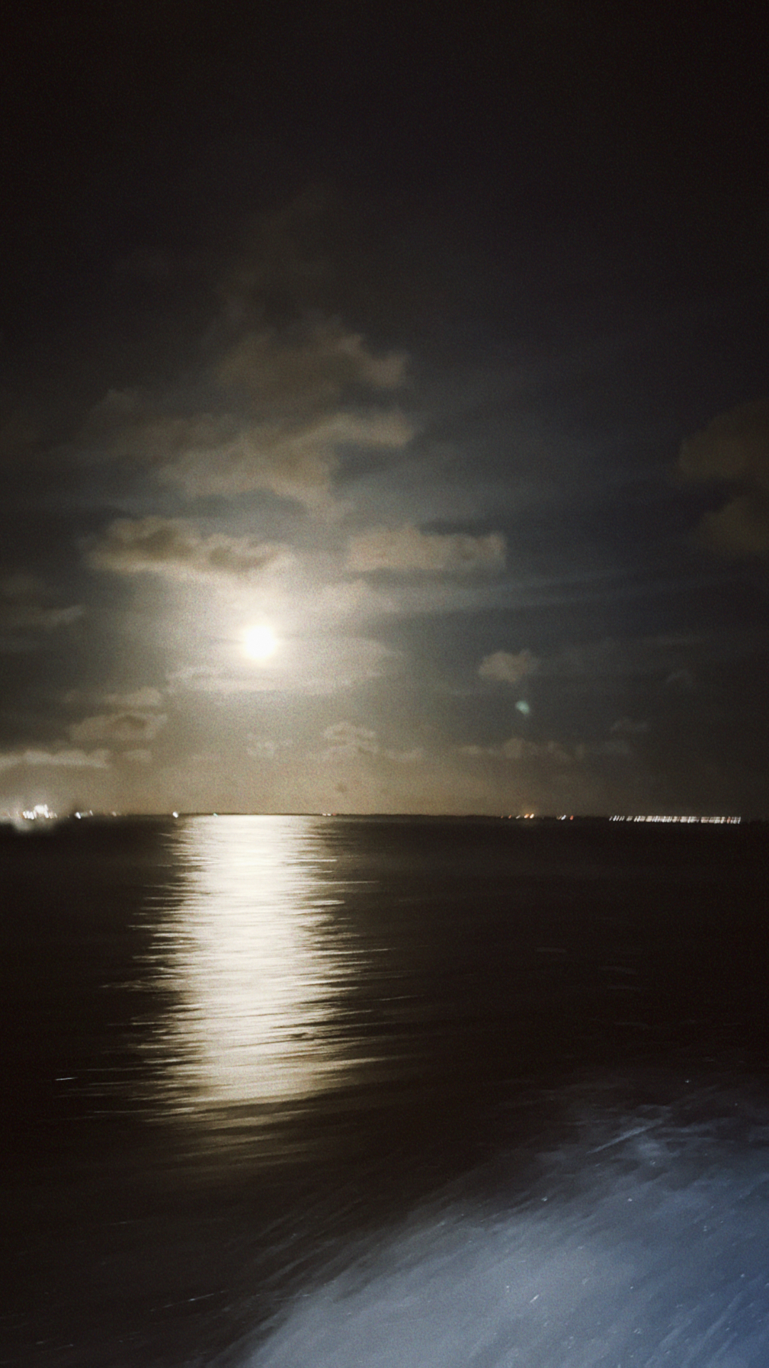 Moonlit night view across the water from the boat