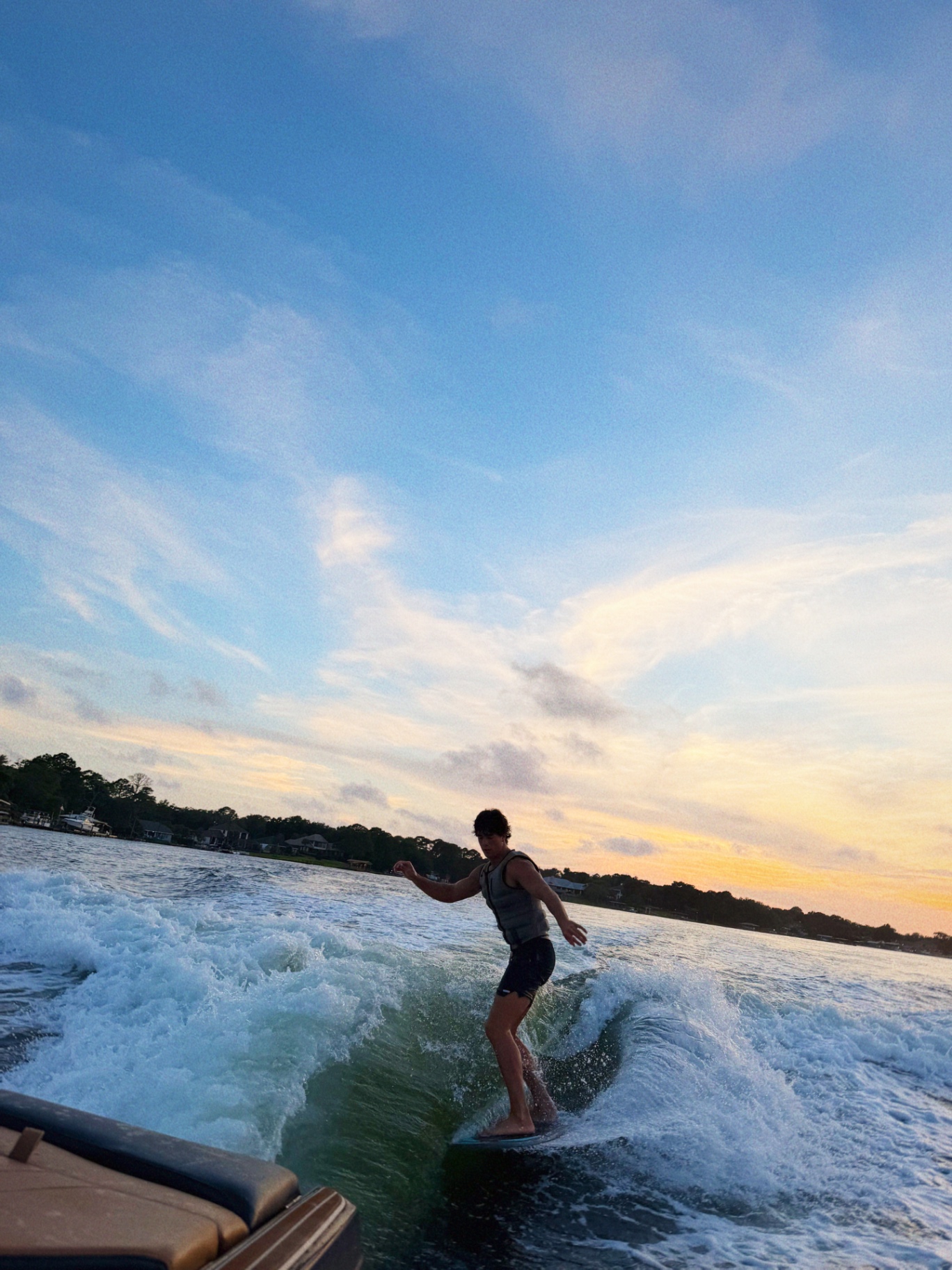 Wakesurfer carving a clean wave at sunset on the bay